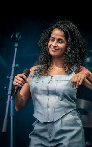 A woman with a microphone in her hand performing