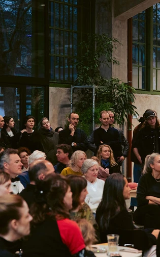 een grote groep mensen staat te kijken naar een presentatie