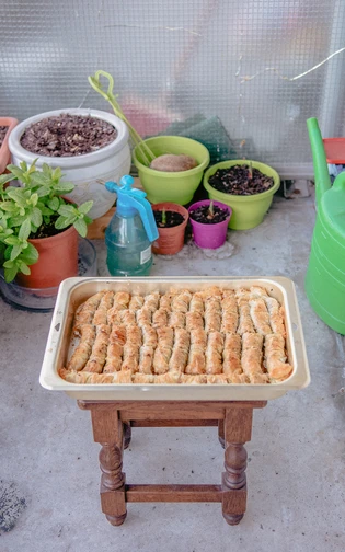 A tray of freshly baked pastry rolls sits on a small wooden table.
