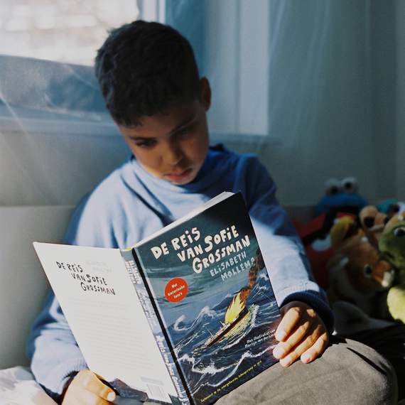 Jens leest De Reis van Sofie Grossman in zijn kamer, foto: Naomi Modde