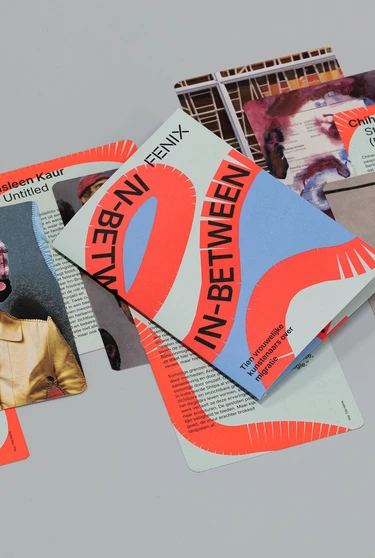 Het boekje en de kaarten van de in-between route liggen uitgestald op een grijze ondergrond.