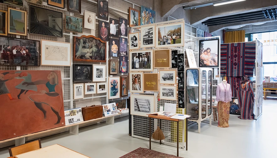 Een depot met objecten uit verschillende culturen, waaronder klederdracht, schilderijen en foto's.